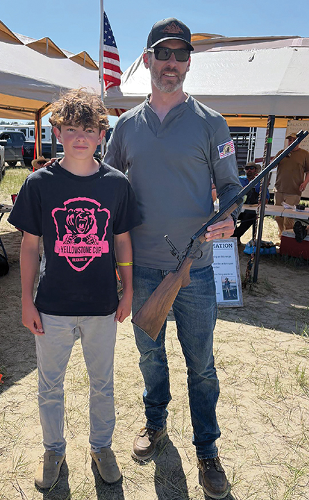 Kyson Ozburn (left) accepts the special  .22 rifle from Zach Schoffstall (right).